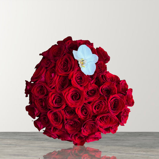 Skye Rose Floral heart-shaped box filled with deep red roses and a single white orchid for a romantic gift.