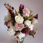 Skye Rose Floral Sophisticated Mauve bouquet with cream and dusty mauve roses and burgundy snapdragons in a vase.