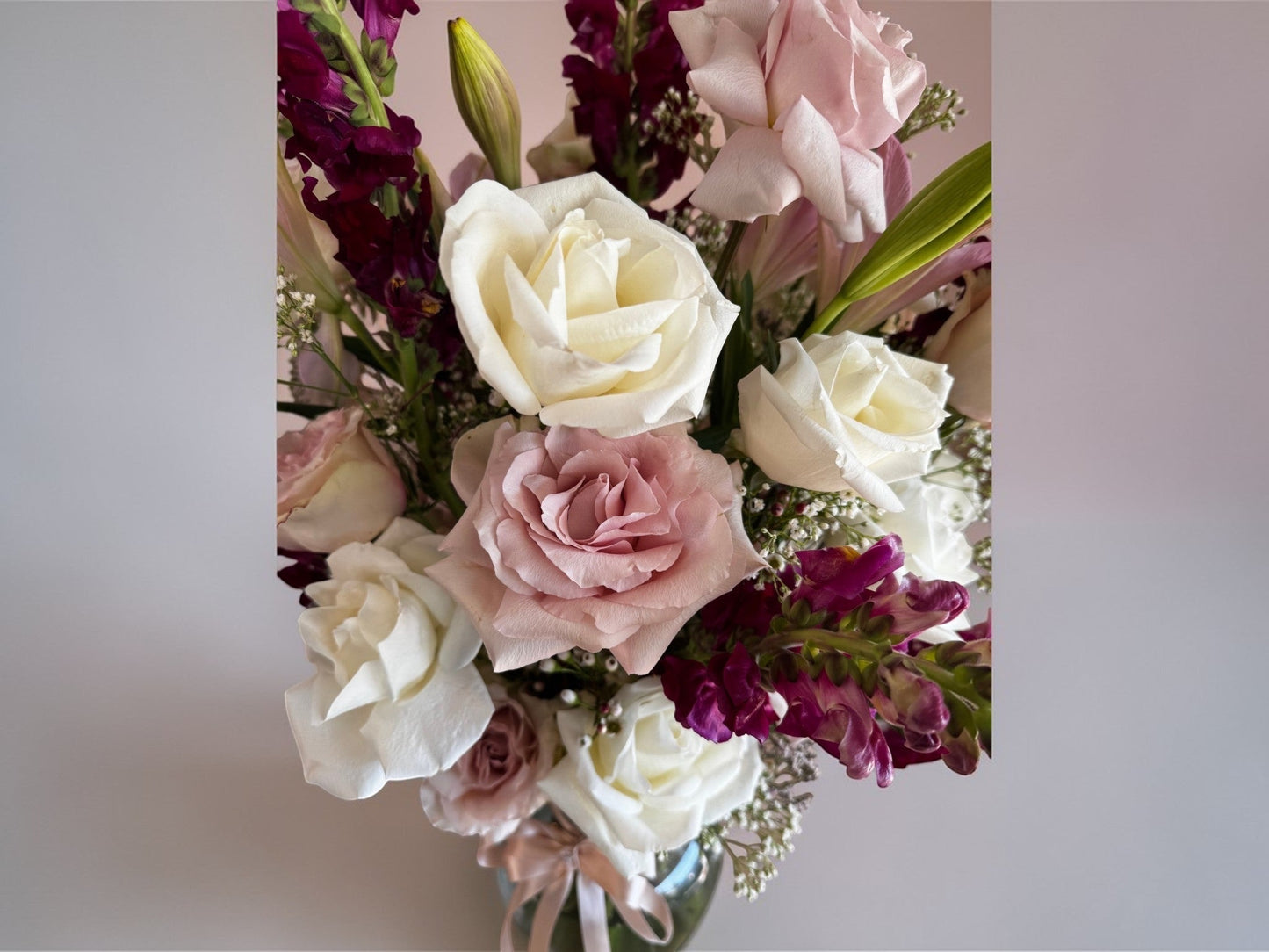 Skye Rose Floral Sophisticated Mauve bouquet with cream and dusty mauve roses and burgundy snapdragons in a vase.