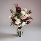 Skye Rose Floral bouquet featuring cream and mauve roses with burgundy snapdragons in a glass vase with a ribbon.