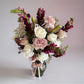 Skye Rose Floral Sophisticated Mauve bouquet with cream and dusty mauve roses and burgundy snapdragons in a vase.